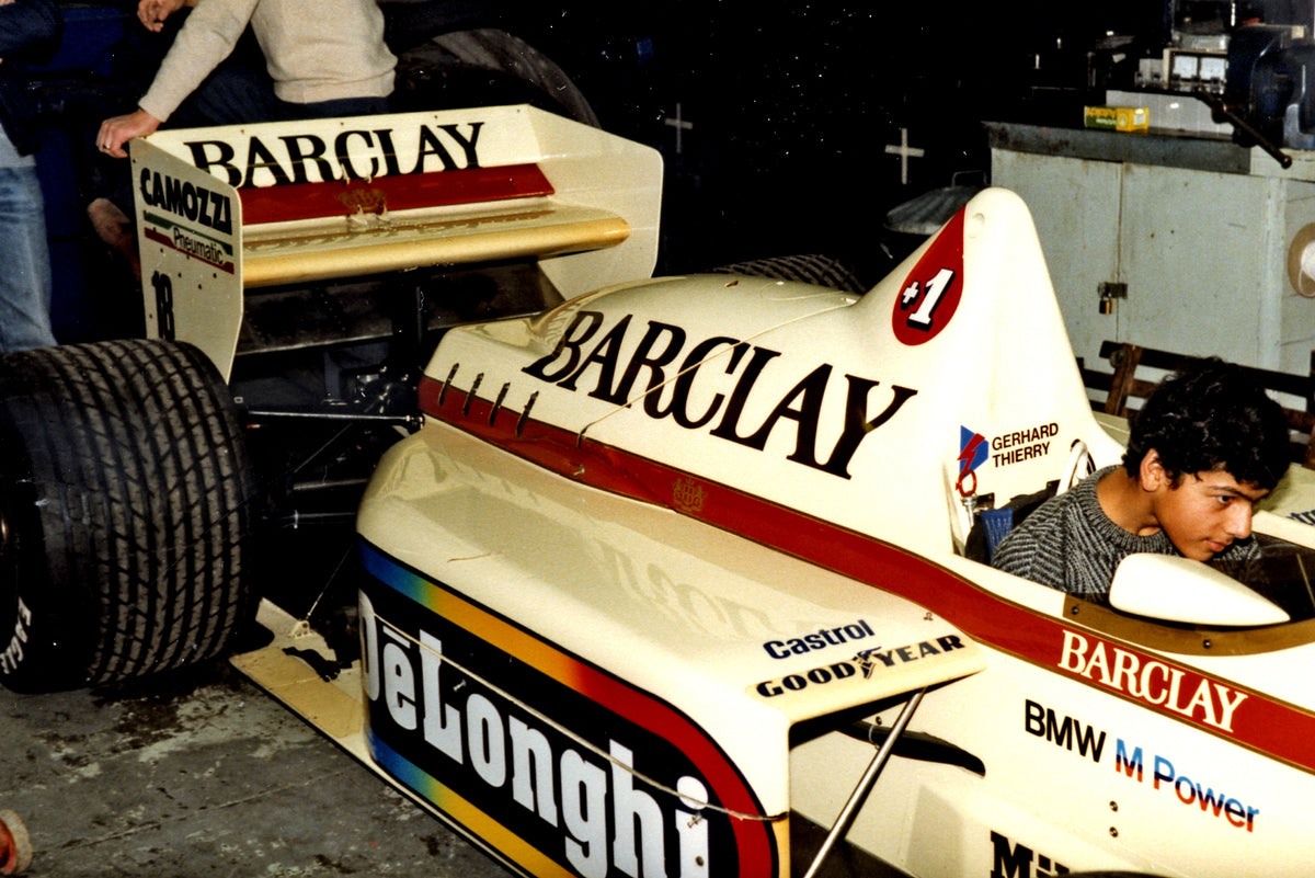 Young Capramont founder beside a Barclay-liveried racing car during a private visit around 1985