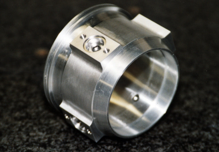 High-temperature alloy engine component with precisely machined bores and fixing features